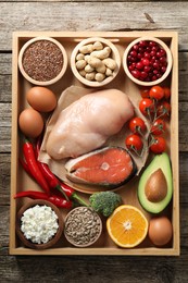 Tray with many different healthy food on wooden table, top view