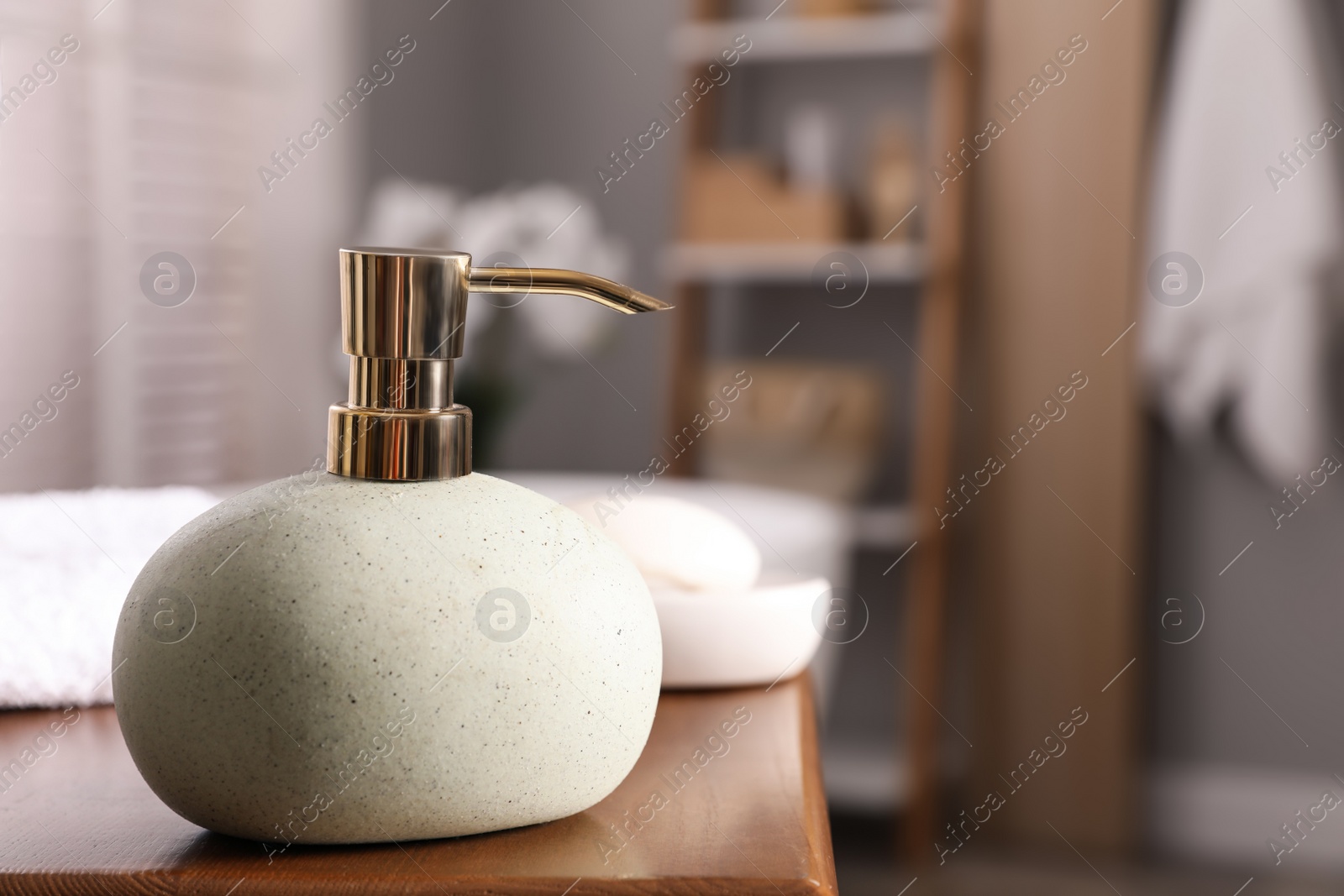 Photo of Dispenser with liquid soap on wooden table in bathroom, space for text