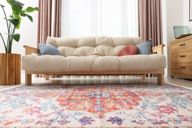 Photo of Beautiful rug and sofa near window indoors, low angle view