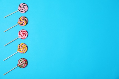 Bright yummy candies and space for text on color background, top view