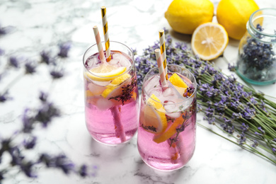 Photo of Fresh delicious lemonade with lavender and straws on white marble table
