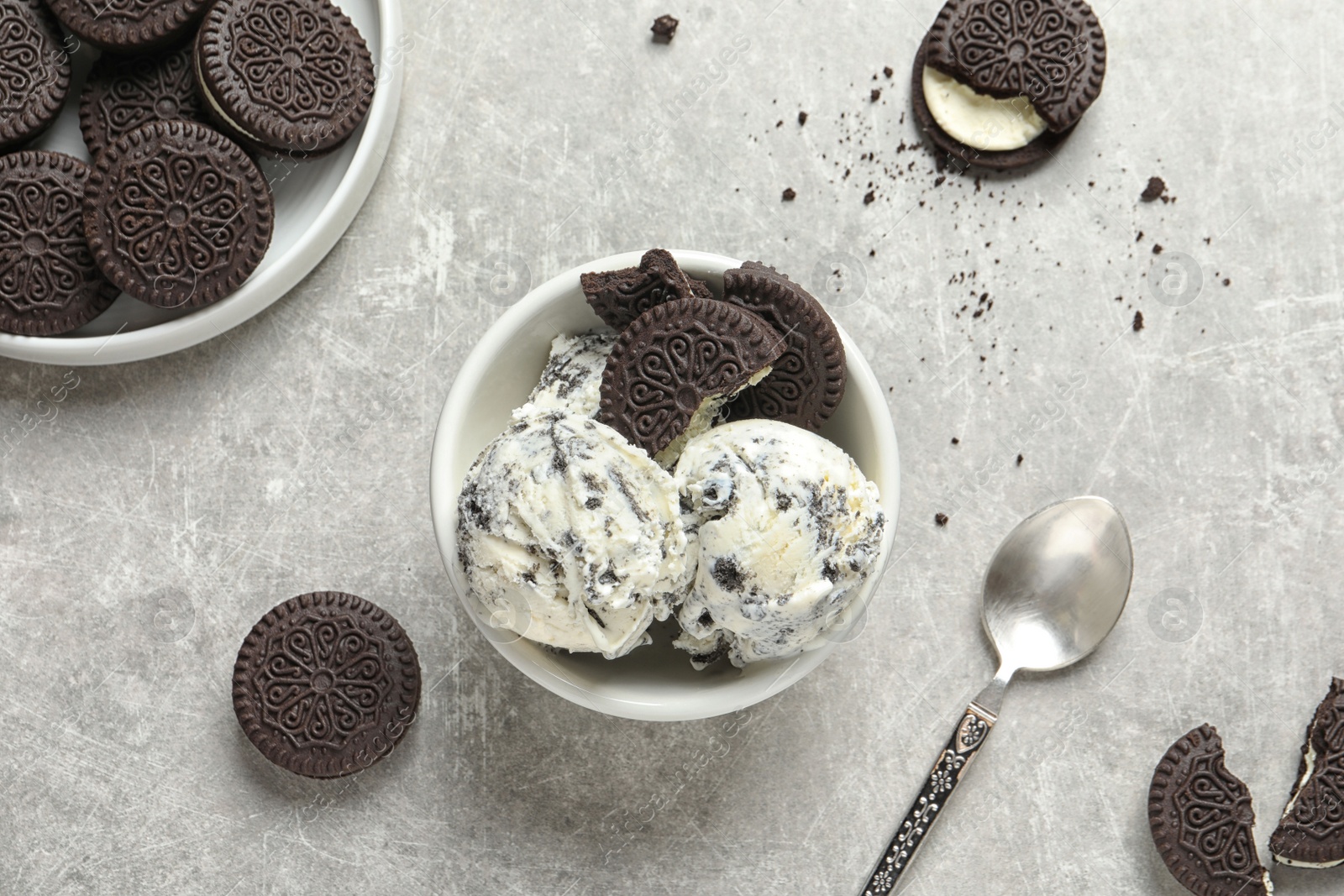 Photo of Flat lay composition with bowl of chocolate cookies ice cream on grey background