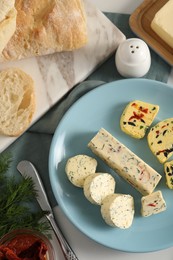 Photo of Different types of tasty butter served on white table, flat lay