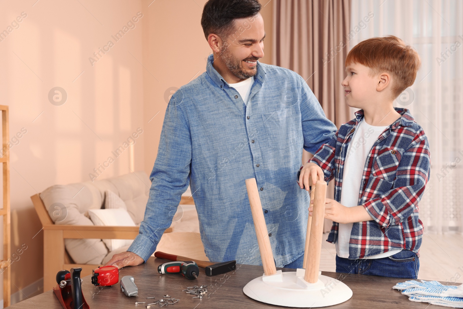 Photo of Father and son making stool at home. Repair work