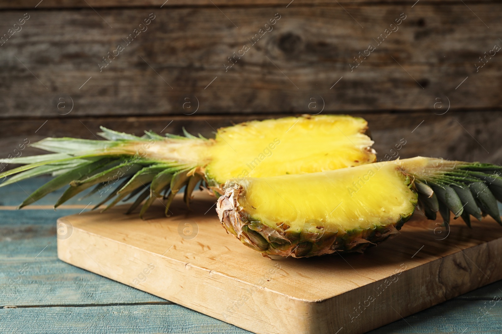 Photo of Board with cut fresh juicy pineapple on wooden table, space for text