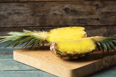 Photo of Board with cut fresh juicy pineapple on wooden table, space for text