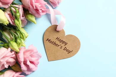 Image of Happy Mother's Day. Heart shaped greeting label and beautiful flowers on light blue background