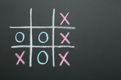 Tic tac toe game drawn on chalkboard