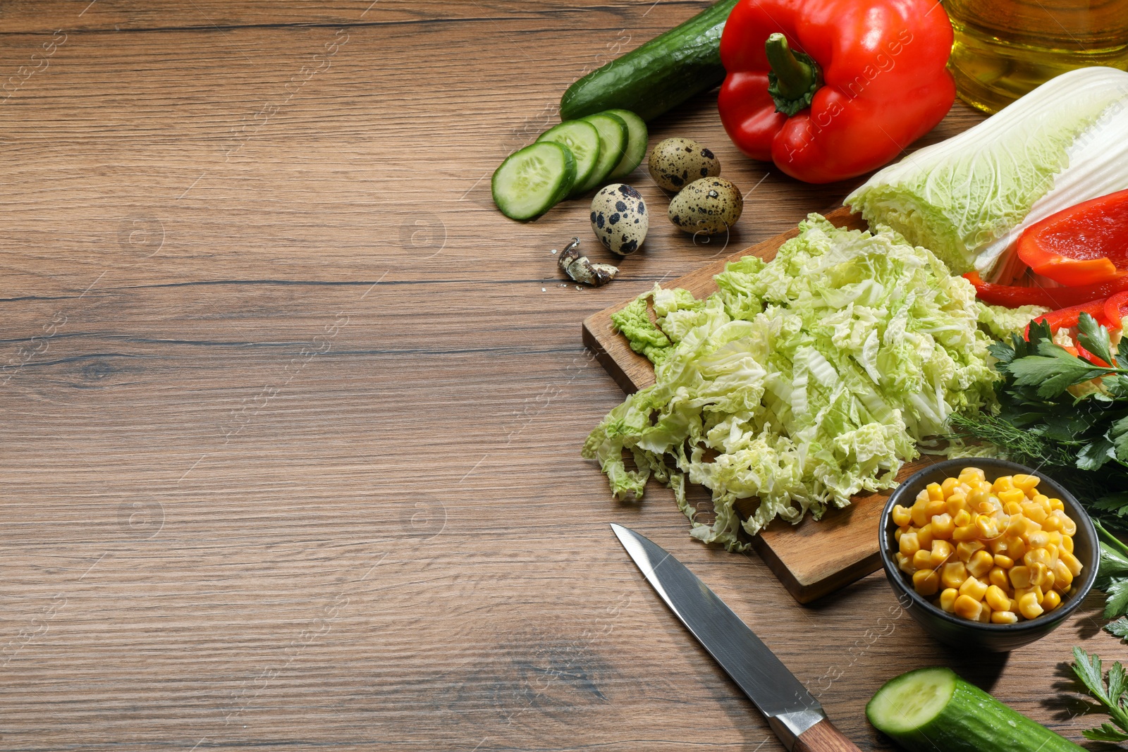 Photo of Chinese cabbage and different products on wooden table, space for text