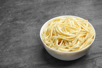 Tasty cooked rice noodles on grey table