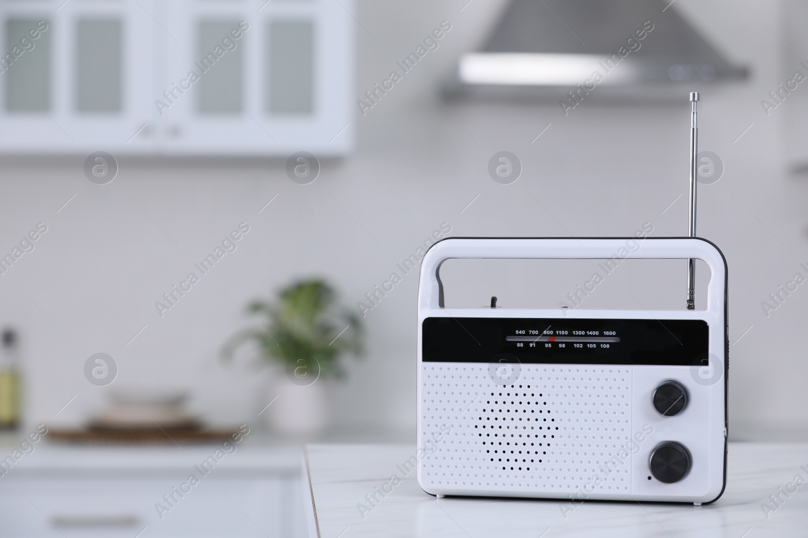 Photo of Stylish radio on white marble table in kitchen. Space for text