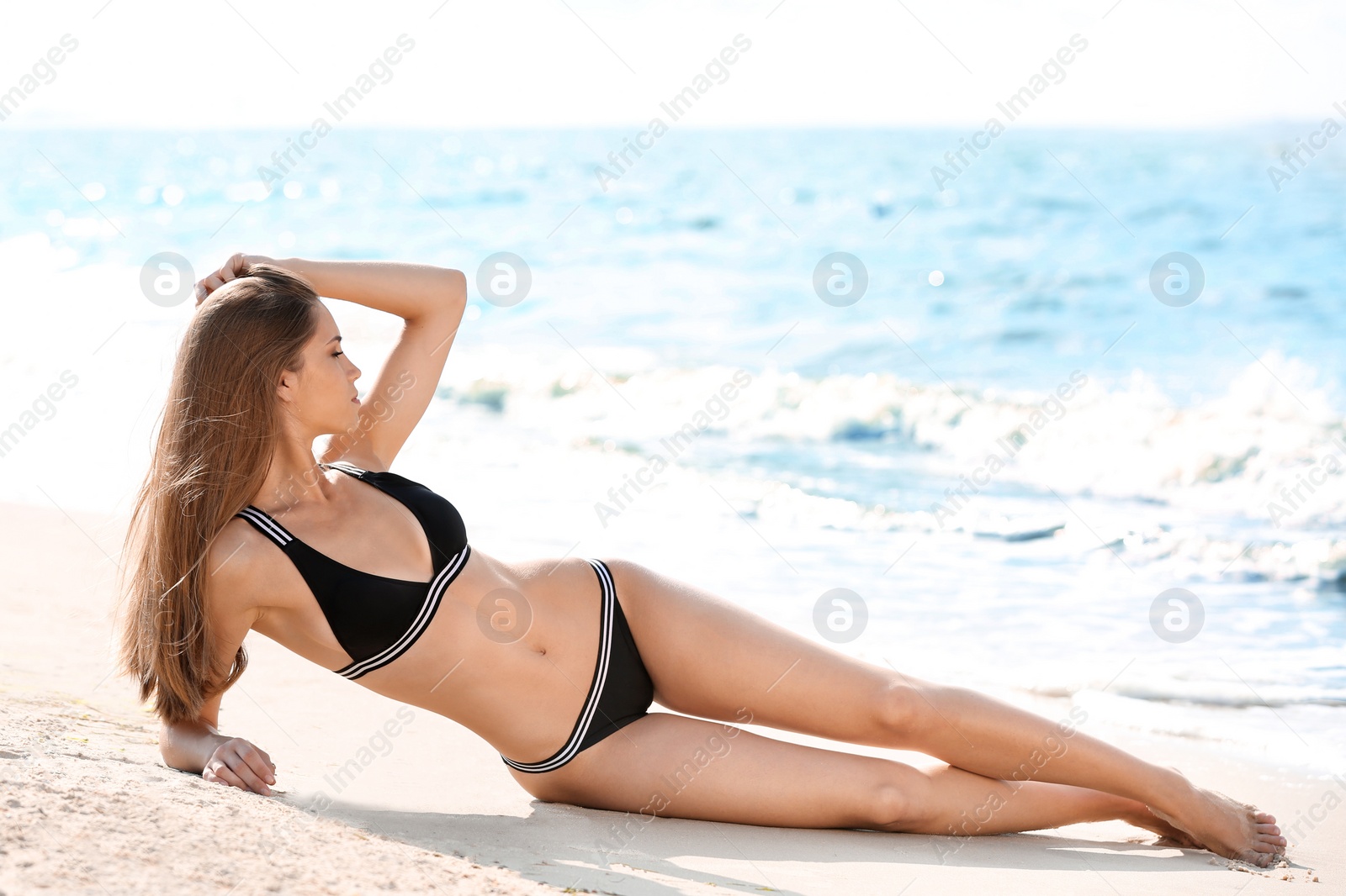 Photo of Attractive young woman in beautiful bikini swimsuit on beach