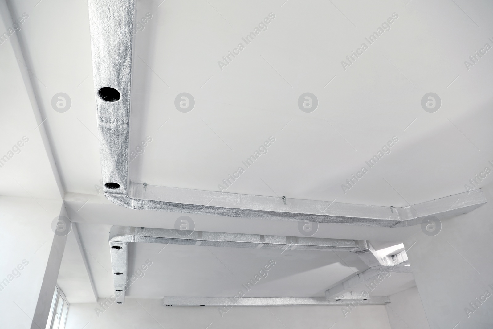 Photo of Ceiling with ventilation system indoors, low angle view