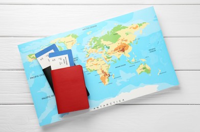Photo of Honeymoon concept. Plane tickets, passports and world map on white wooden table, top view