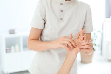 Photo of Woman receiving hand massage in wellness center, closeup