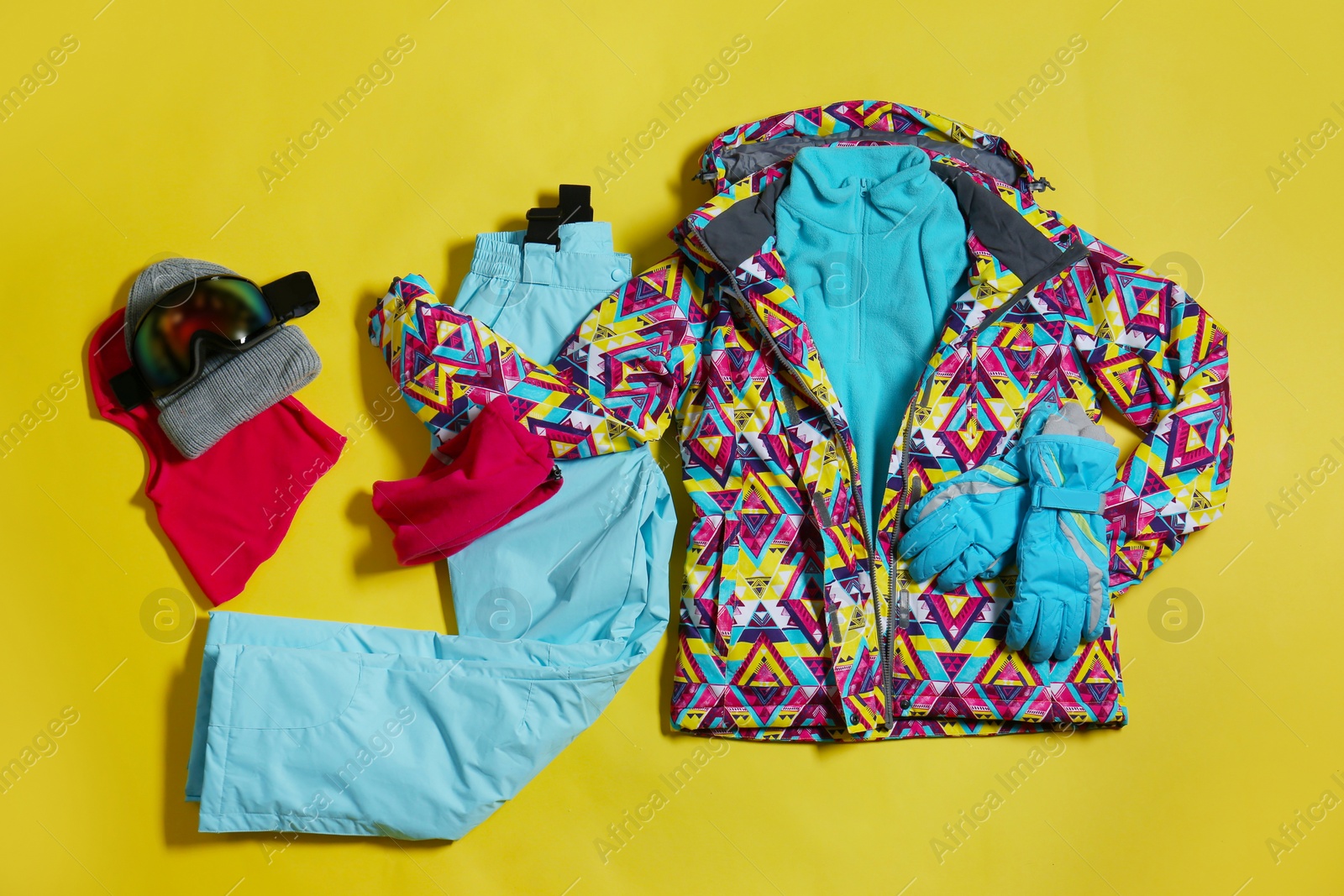 Photo of Stylish winter sport clothes on yellow background, flat lay