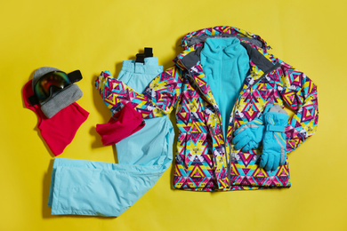 Photo of Stylish winter sport clothes on yellow background, flat lay