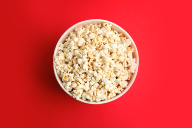 Tasty pop corn on red background, top view