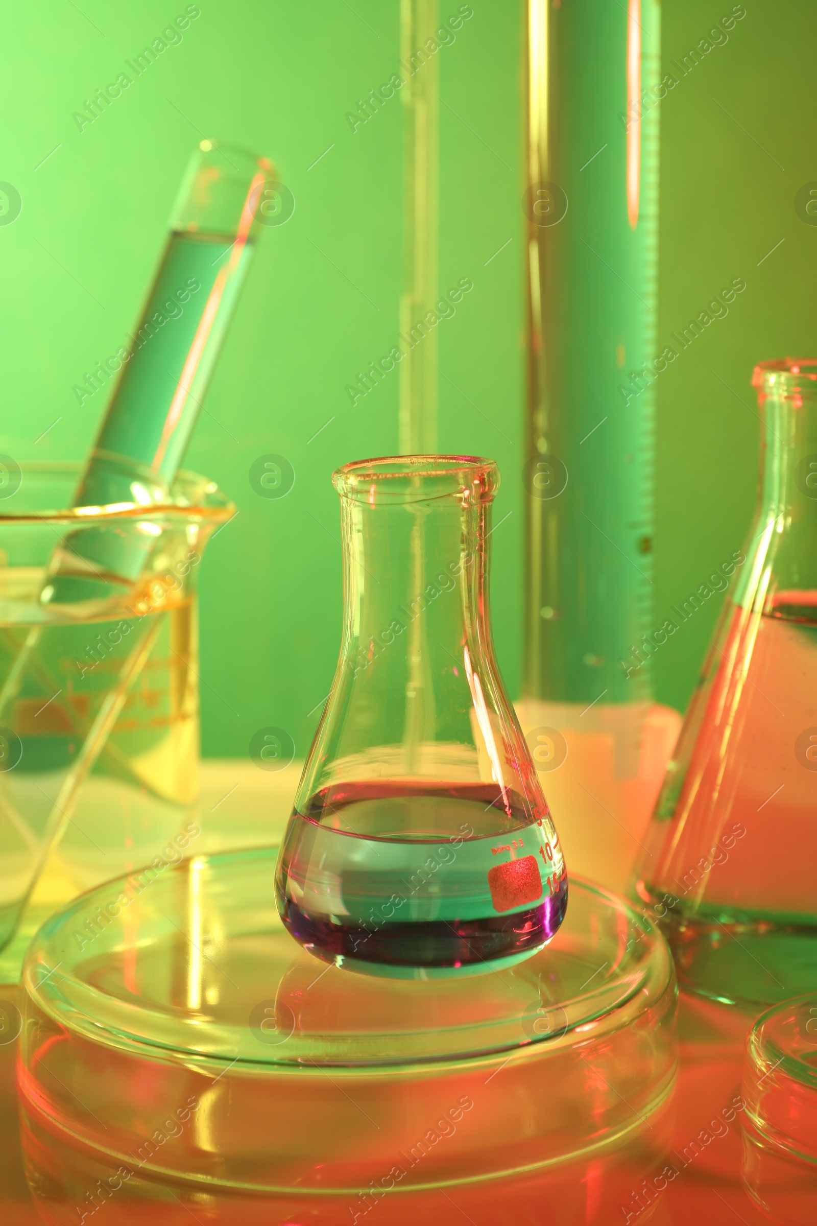 Photo of Laboratory analysis. Different glassware on table against color background, closeup