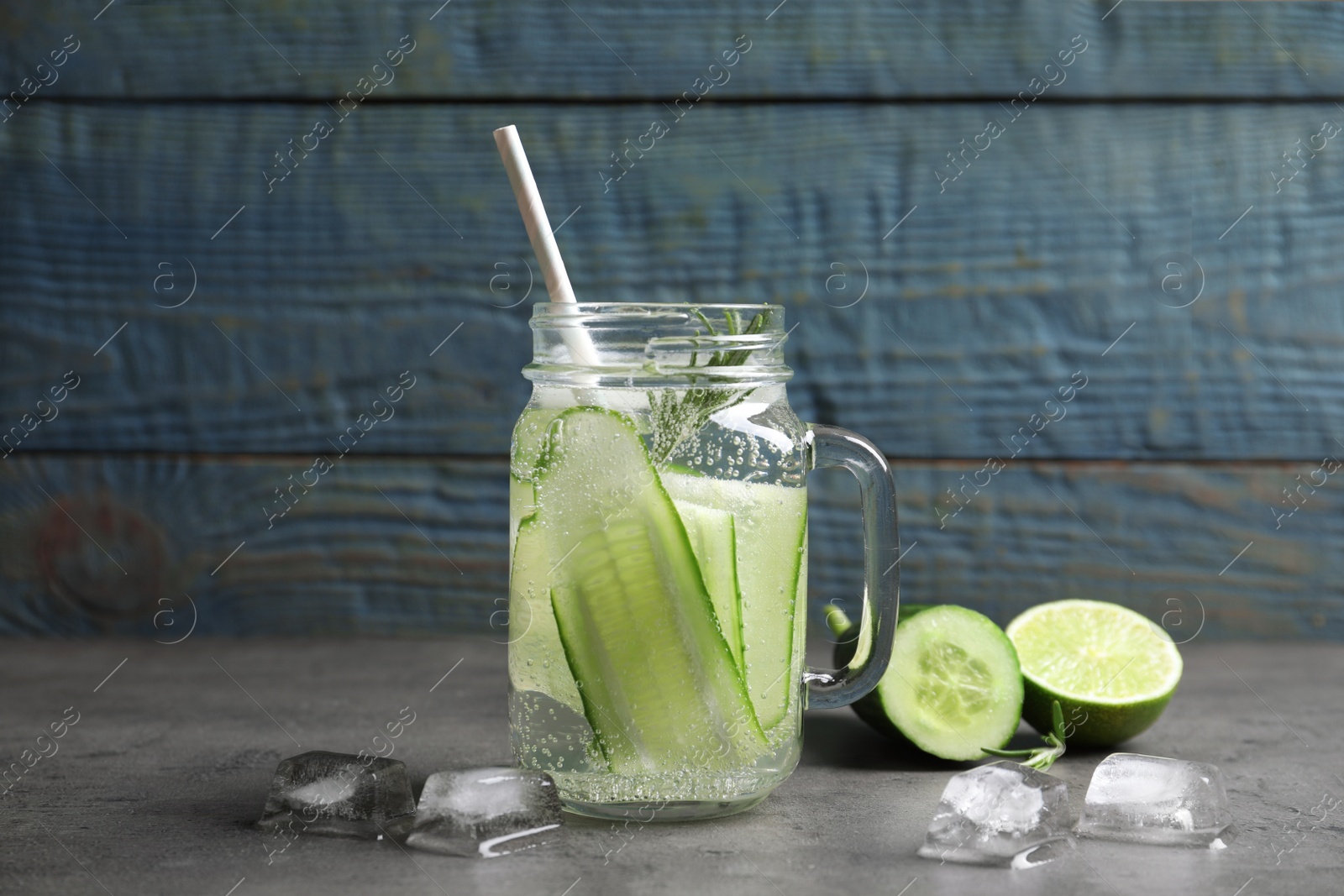 Photo of Mason jar with fresh cucumber water on table