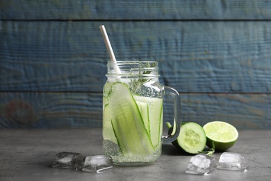 Photo of Mason jar with fresh cucumber water on table