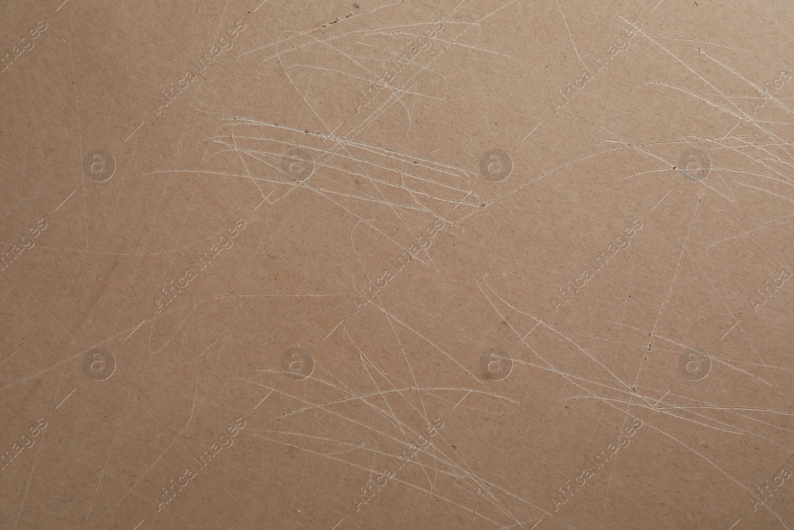 Photo of Old fiberboard with scratches as background, closeup