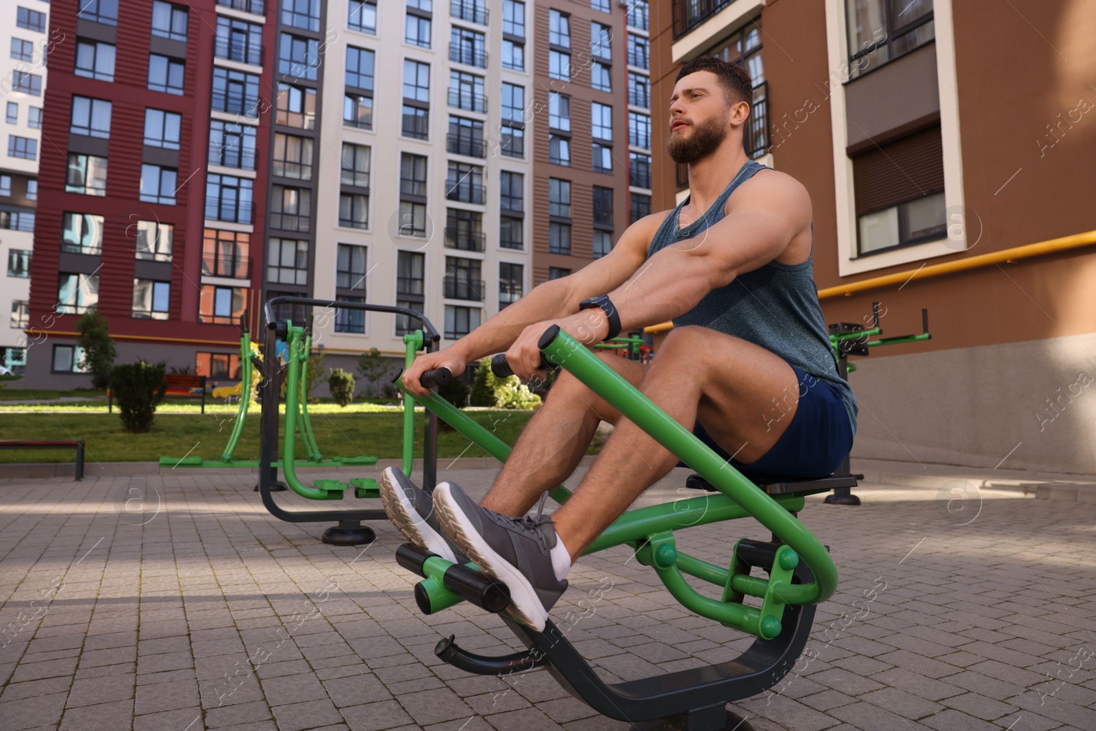 Photo of Man training on rowing machine at outdoor gym