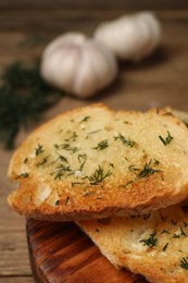 Photo of Tasty baguette with garlic and dill on table, closeup
