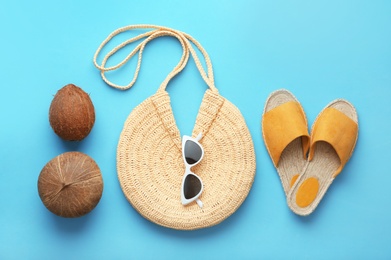 Flat lay composition with woman's straw bag on light blue background