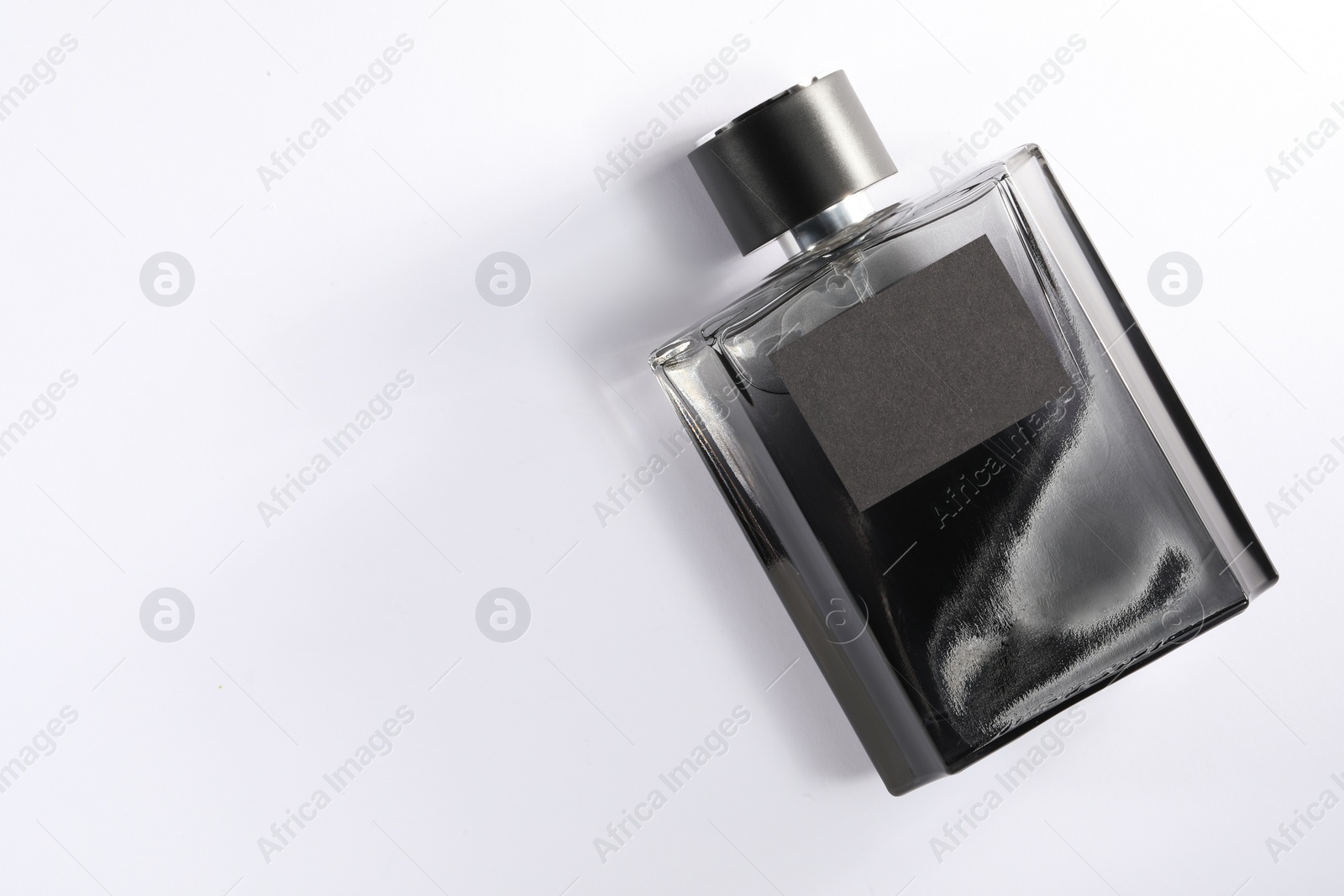 Photo of Luxury men`s perfume in bottle on white background, top view. Space for text