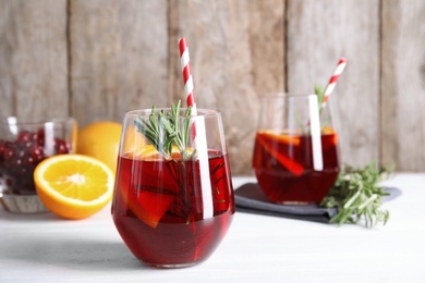 Tasty refreshing cranberry cocktail with rosemary on table