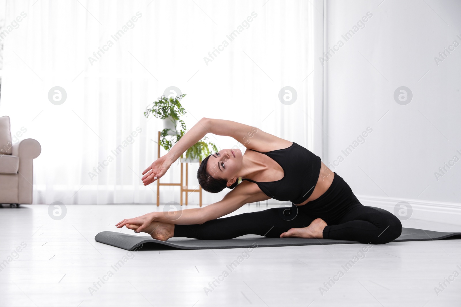 Photo of Professional young acrobat practicing yoga at home