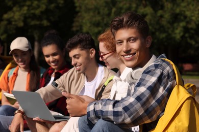 Group of happy young students learning together in park