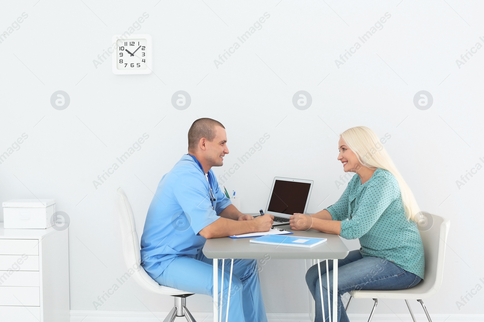 Photo of Male medical assistant consulting female patient in clinic