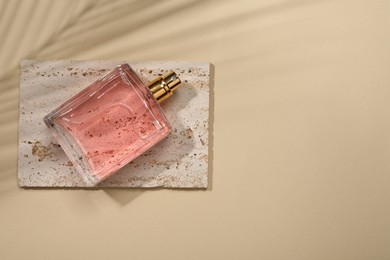 Photo of Luxury women's perfume in bottle on beige background, top view. Space for text