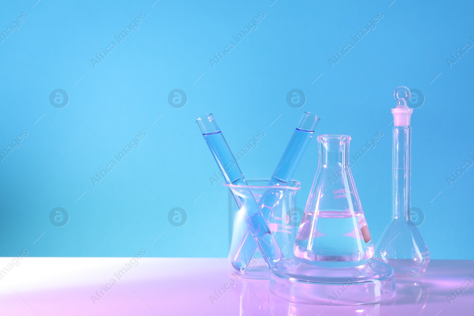 Photo of Laboratory analysis. Different glassware on table against light blue background