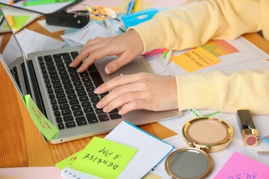 Photo of Woman using laptop at messy table, closeup. Concept of being overwhelmed by work