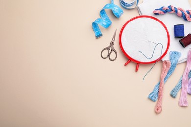 Photo of Flat lay composition with embroidery hoop on beige background. Space for text