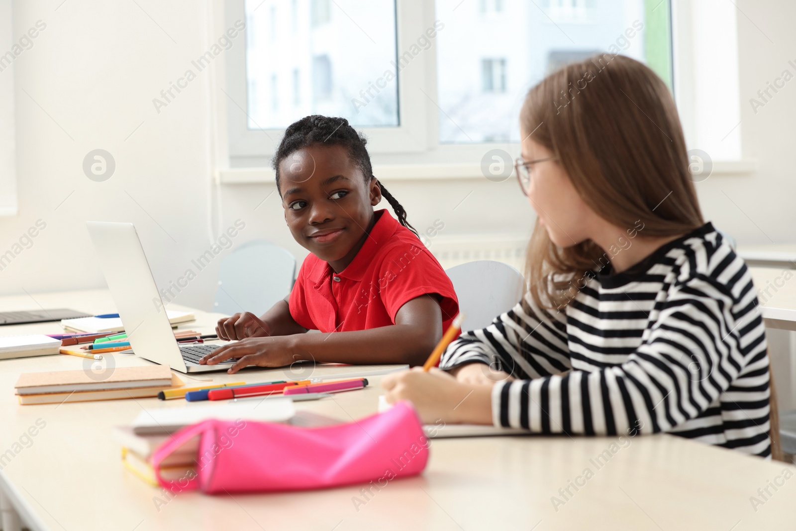 Photo of Cute children studying in classroom at school