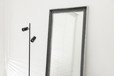 Photo of Stylish makeup room interior with long mirror and lamp