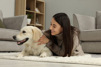 Happy woman with cute Labrador Retriever dog on floor at home. Adorable pet