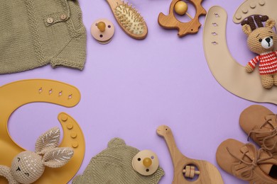 Flat lay composition with baby accessories and bib on violet background, space for text