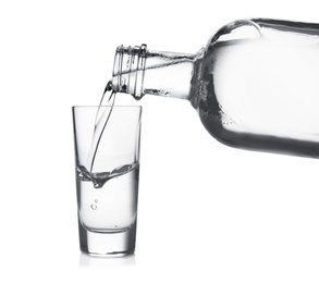 Photo of Pouring vodka into shot glass on white background