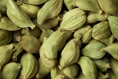 Photo of Dry green cardamom pods as background, closeup