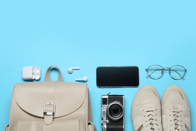 Flat lay composition with stylish backpack on light blue background, space for text