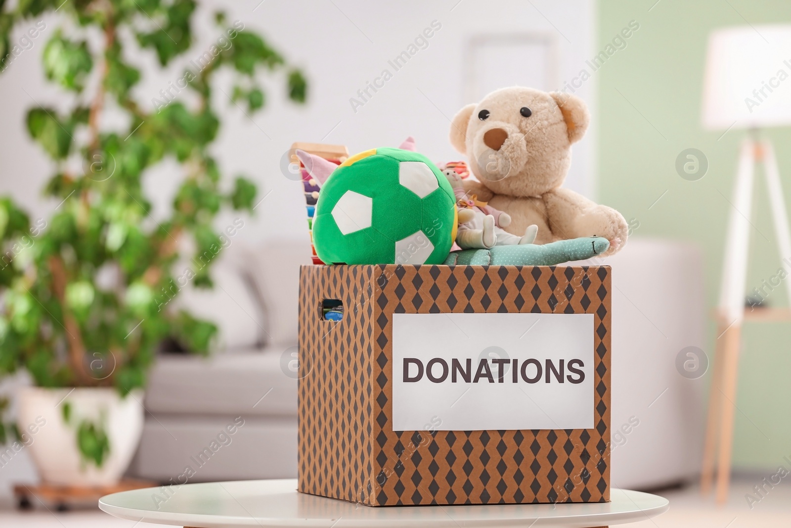 Photo of Donation box with toys on table indoors