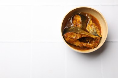 Tasty fish curry on white tiled table, top view. Space for text. Indian cuisine