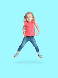 Image of Happy cute girl jumping on light blue background