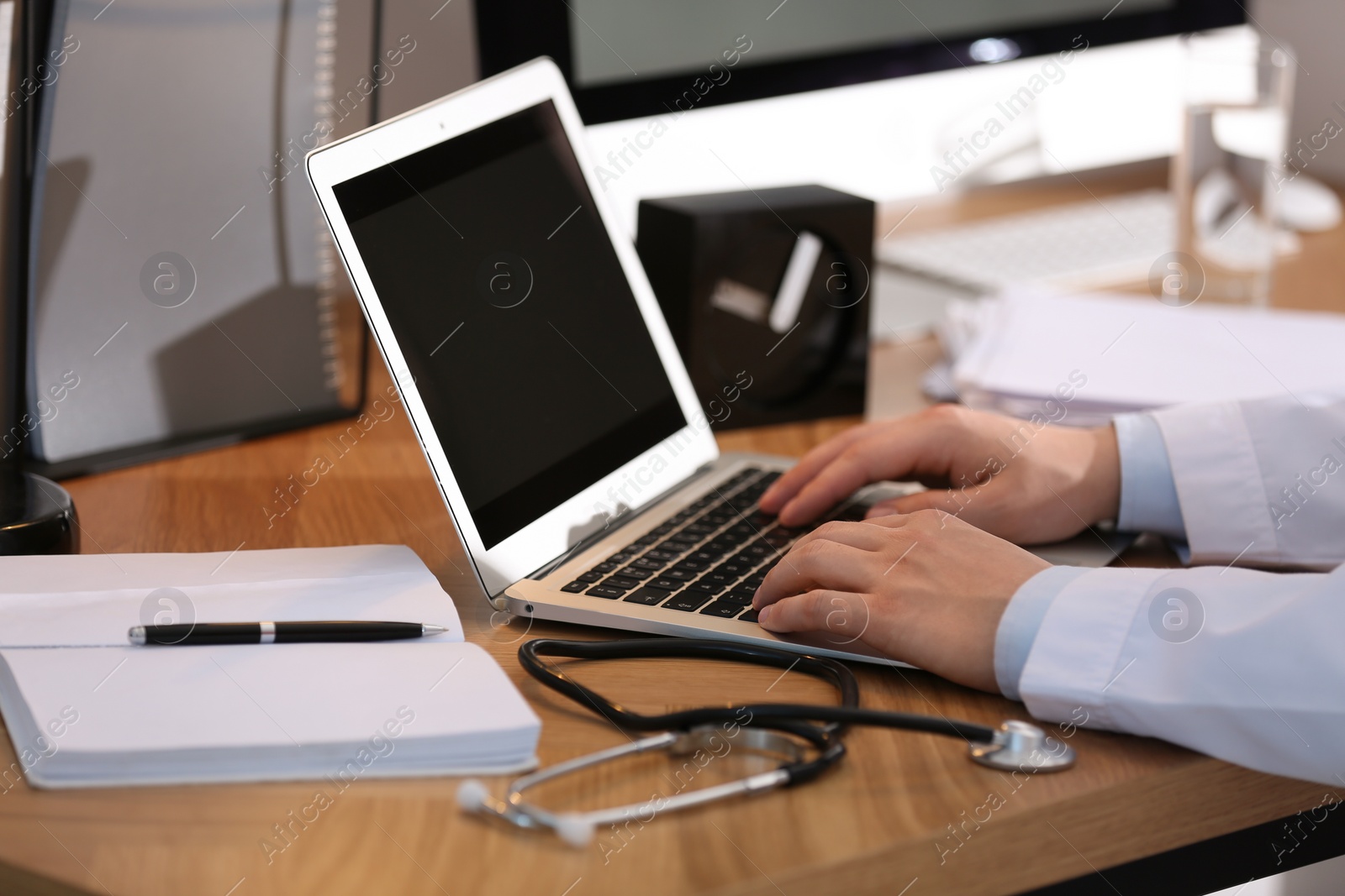 Photo of Professional doctor working on laptop in office, closeup