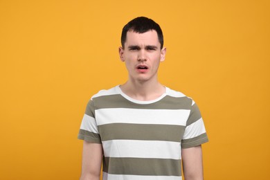 Photo of Portrait of surprised man on orange background